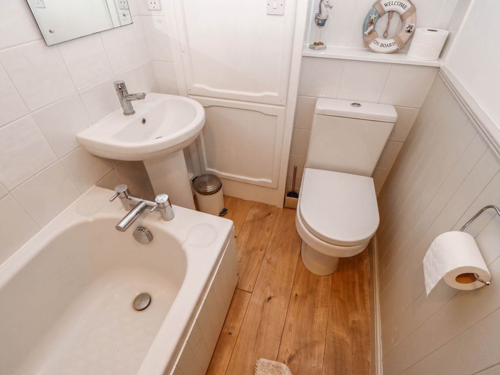 A bathroom with a sink, bathtub, and toilet at Kernot Cottage in Reeth