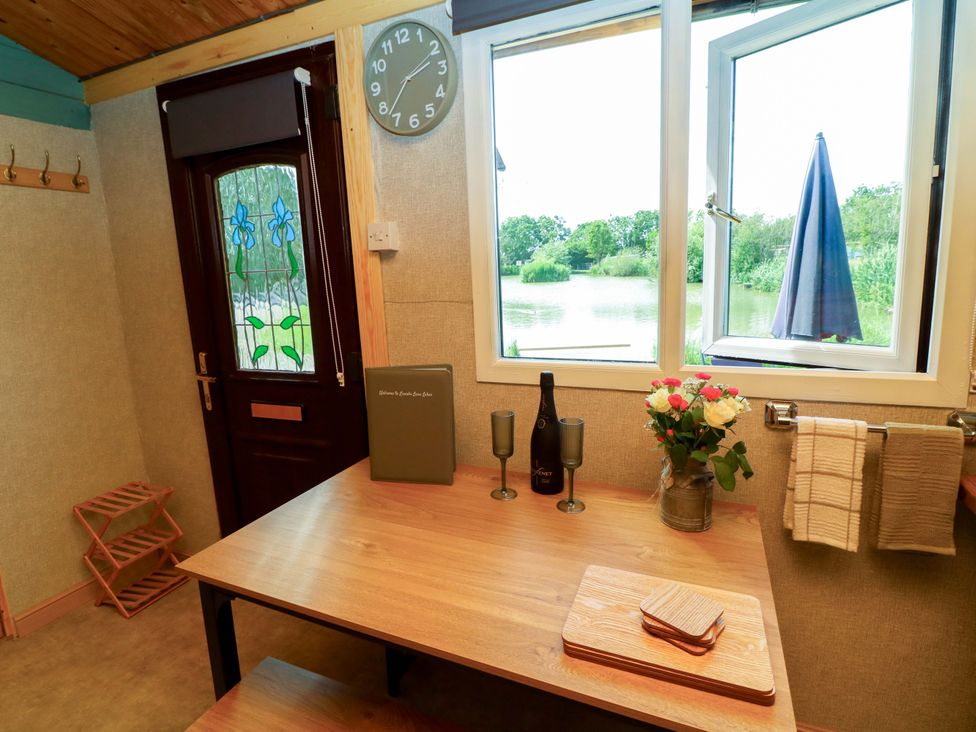 A kitchen with a table and flowers at Moorhen Lodge in Market Rasen