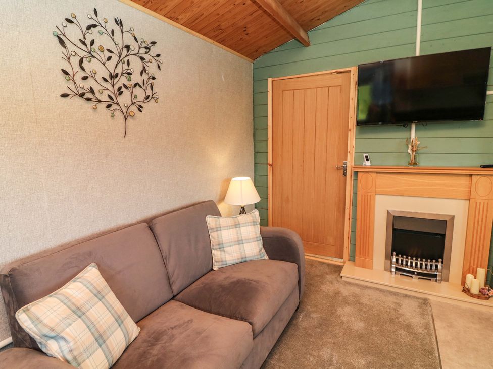A living room with a sofa and television at Moorhen Lodge in Market Rasen