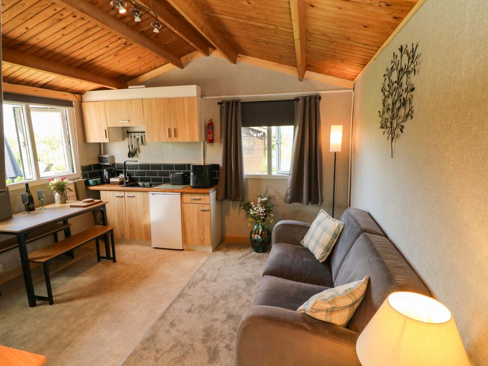 A kitchen with a table and sofa at Moorhen Lodge in Market Rasen