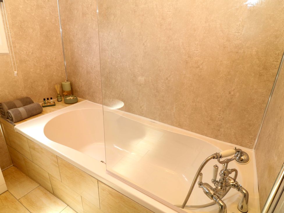 A bathroom with a bathtub and accessories at Moorhen Lodge in Market Rasen