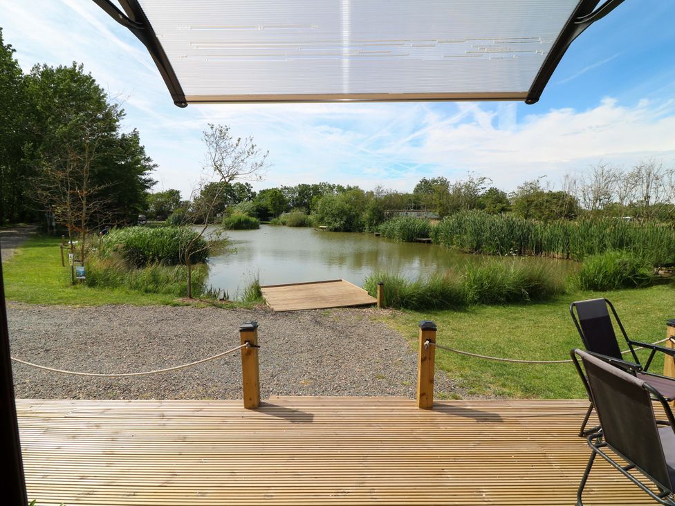 An outdoor area with a view of water and greenery at Moorhen Lodge, Market Rasen