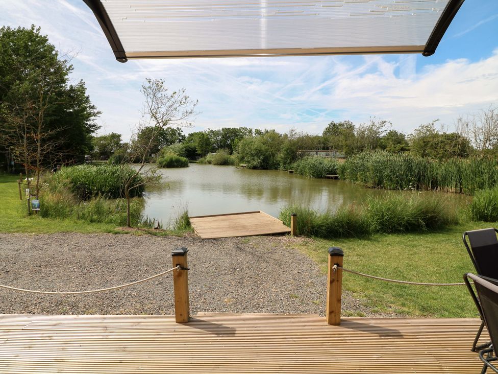 A view overlooking a pond from a deck at Moorhen Lodge in Market Rasen