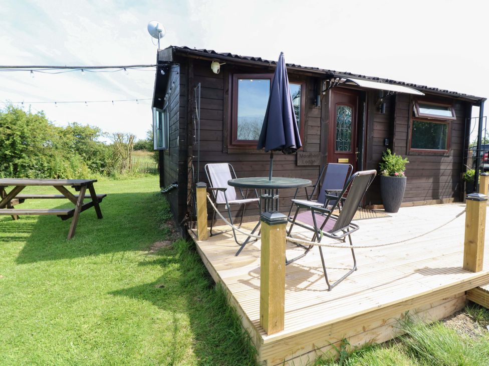 An outdoor seating area with a table and chairs at Moorhen Lodge in Market Rasen