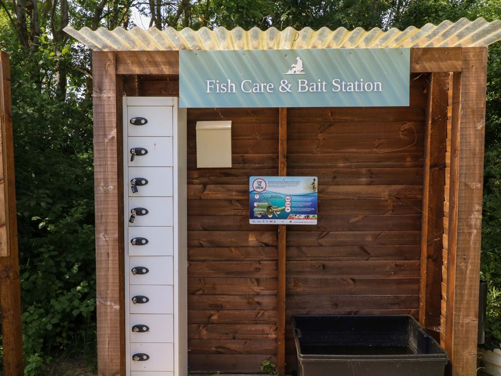 A fish care and bait station with lockers and an information sign at Moorhen Lodge in Market Rasen