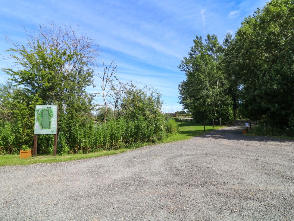 An outdoor space with a gravel path and a sign at Moorhen Lodge in Market Rasen