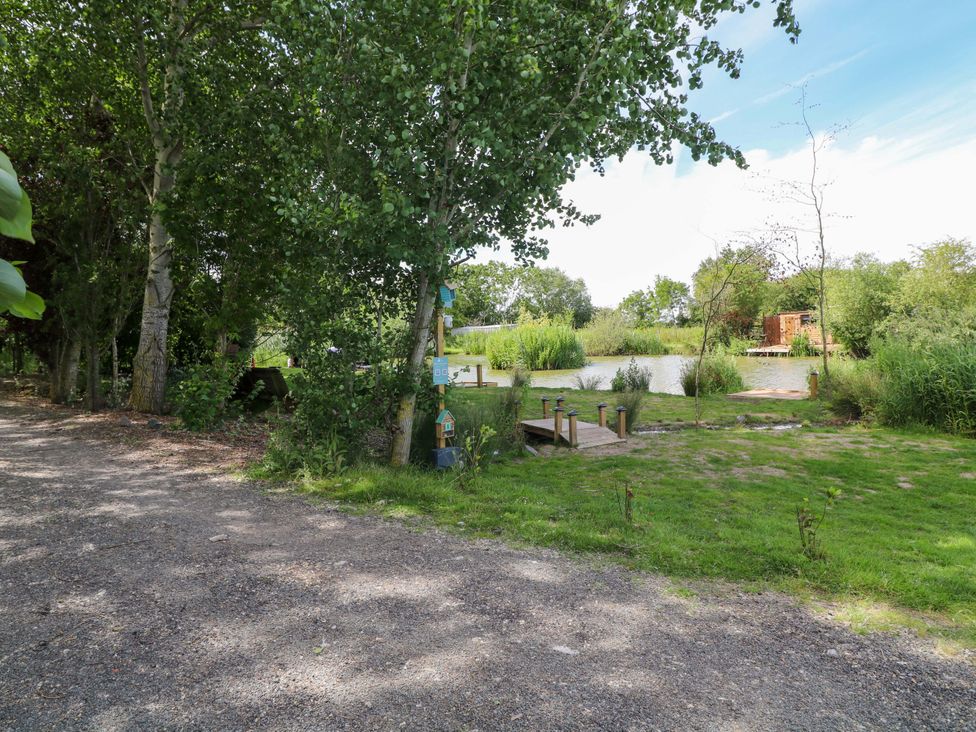 An outdoor area with trees and a dock at Moorhen Lodge in Market Rasen