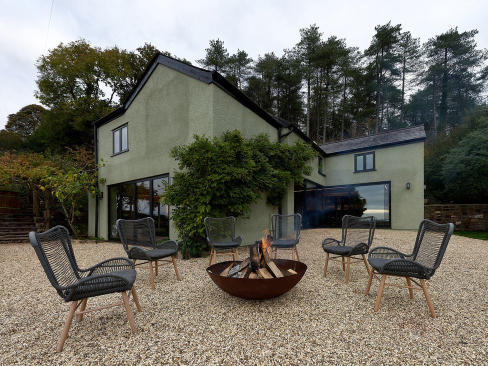 An outdoor area with a fire pit and chairs at Providence Cottage in Trellech