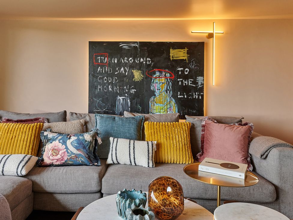 A living room with a sofa and artwork at Providence Cottage, Trellech