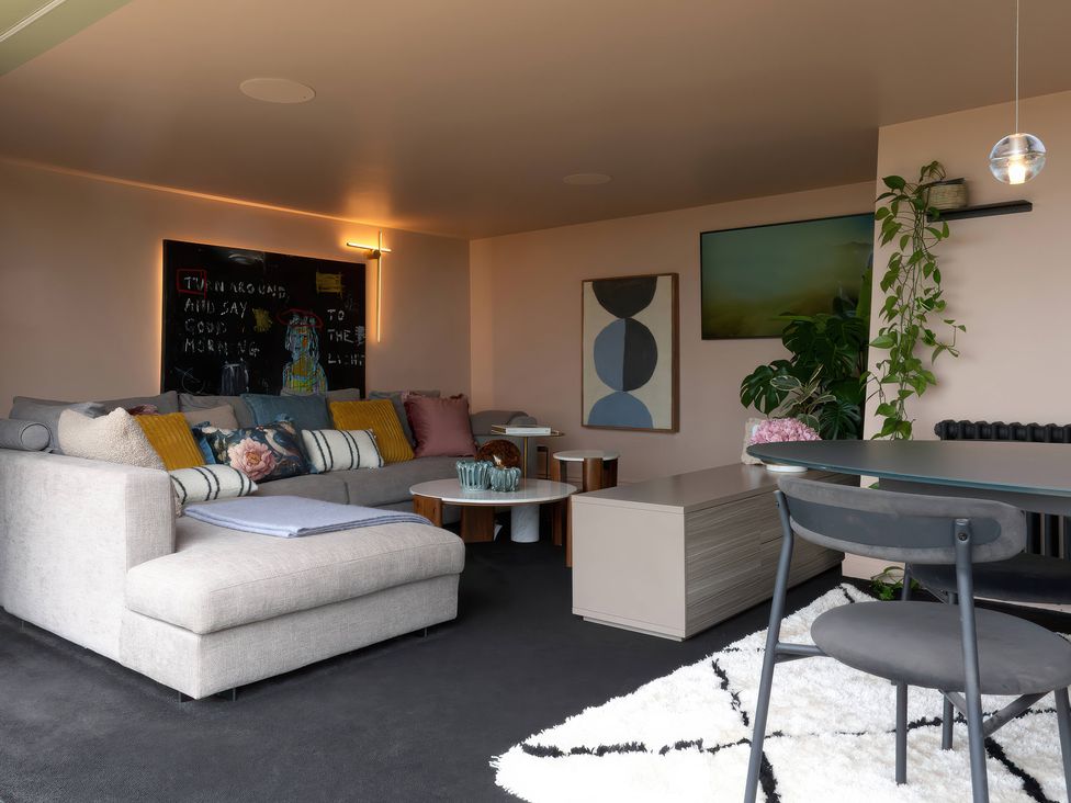 A living room with a sofa, coffee table, and artwork at Providence Cottage in Trellech