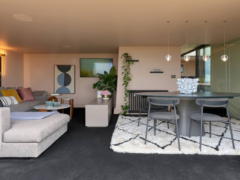 A living room with a sofa and dining area at Providence Cottage in Trellech