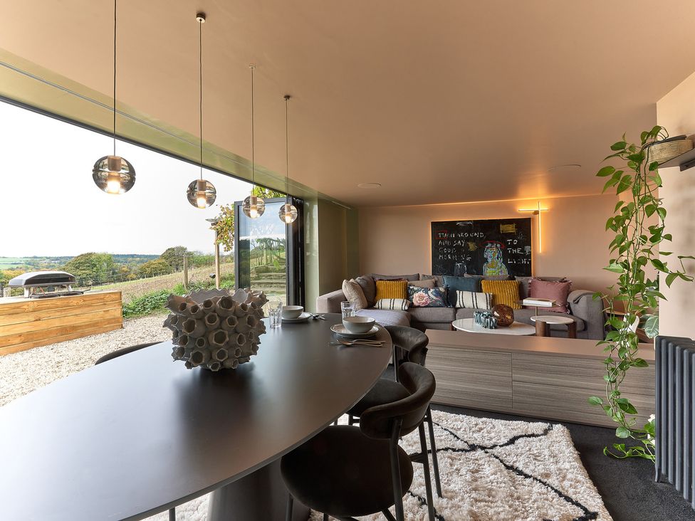 A living room with a sofa and dining table at Providence Cottage Trellech