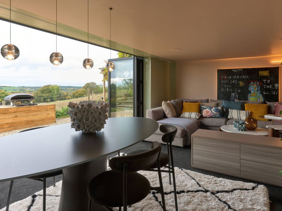A living room with a sofa, dining table and chairs at Providence Cottage in Trellech