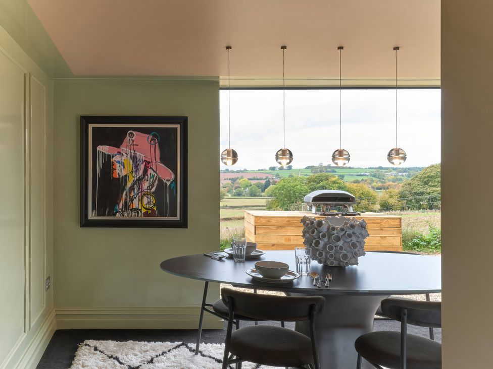 A dining room with a table and artwork at Providence Cottage Trellech