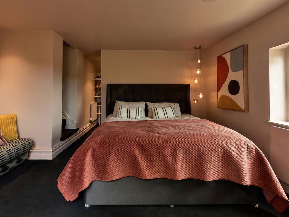 A bedroom with a bed and artwork at Providence Cottage in Trellech