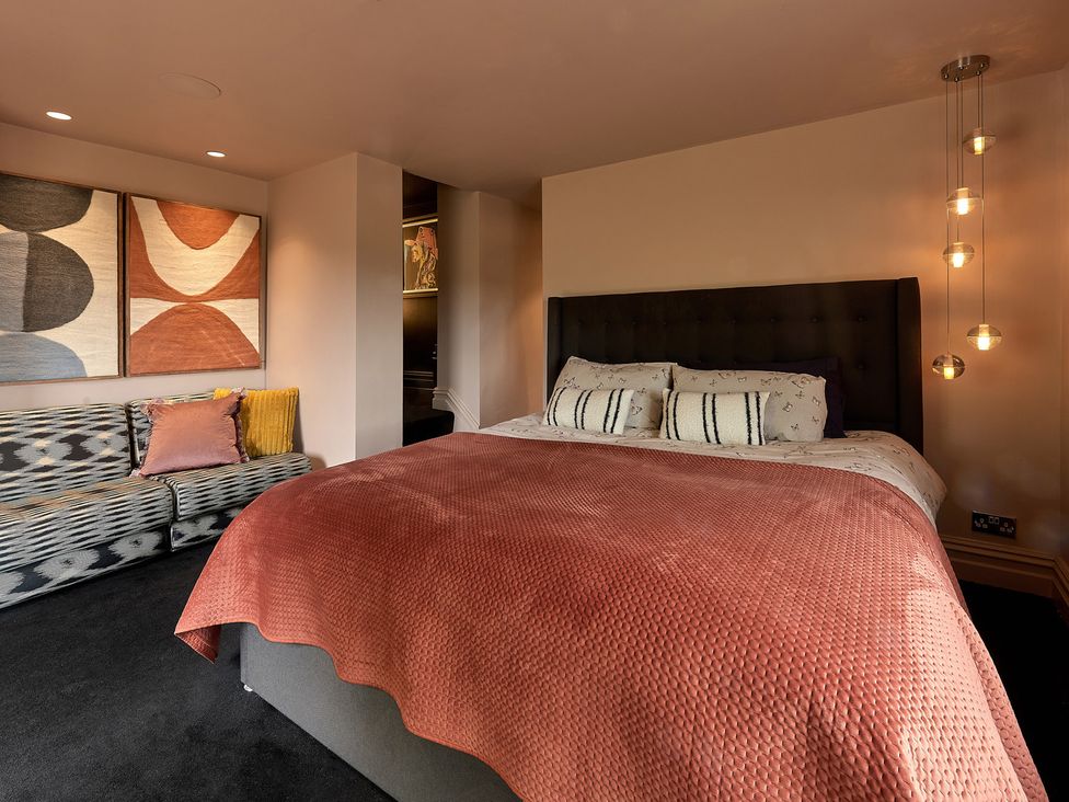 A bedroom with a bed and a sofa at Providence Cottage in Trellech