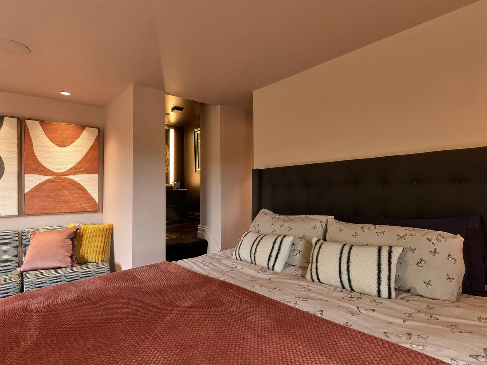 A bedroom with a bed and wall art at Providence Cottage Trellech