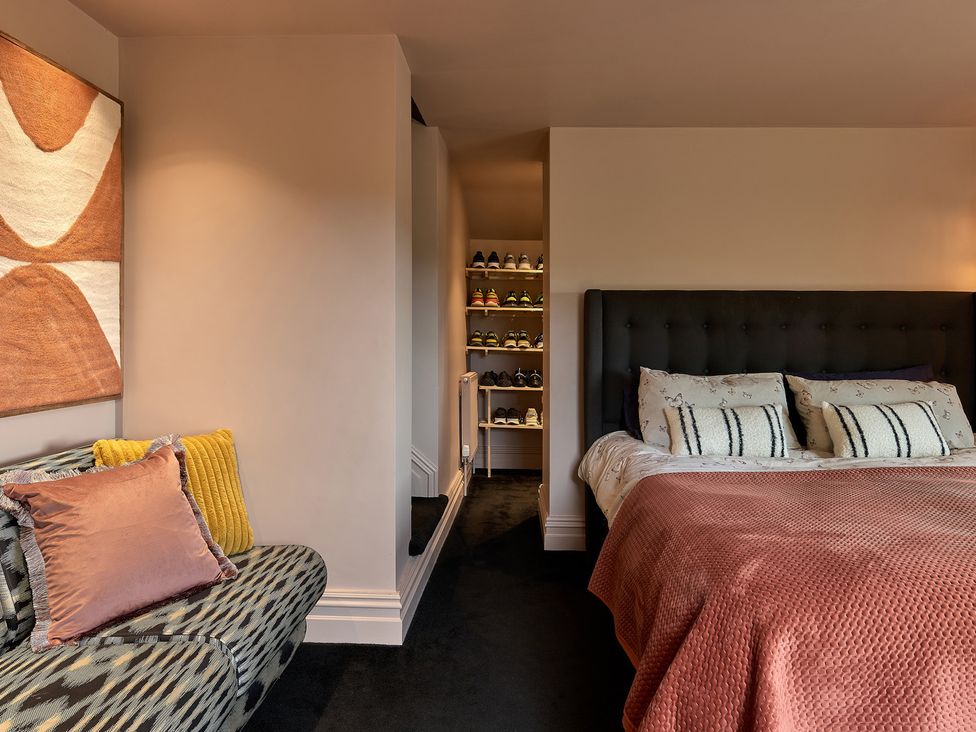 A bedroom with a bed and a sofa at Providence Cottage Trellech