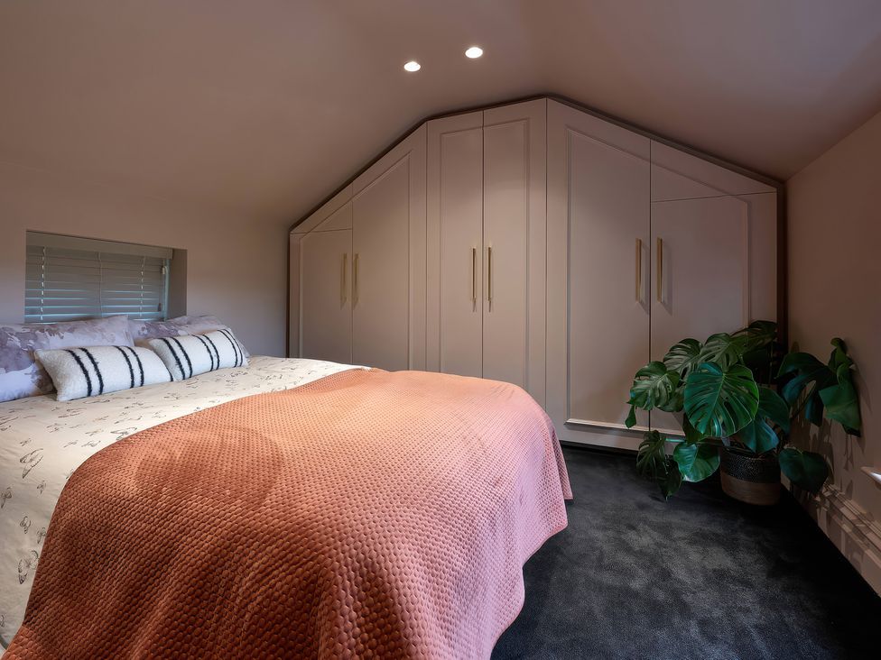 A bedroom with a bed and wardrobe at Providence Cottage Trellech