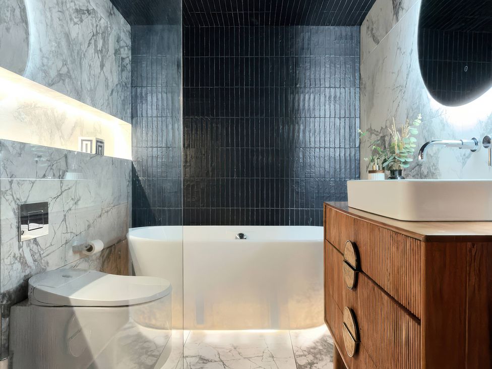 A bathroom with a bathtub, toilet and sink at Providence Cottage in Trellech
