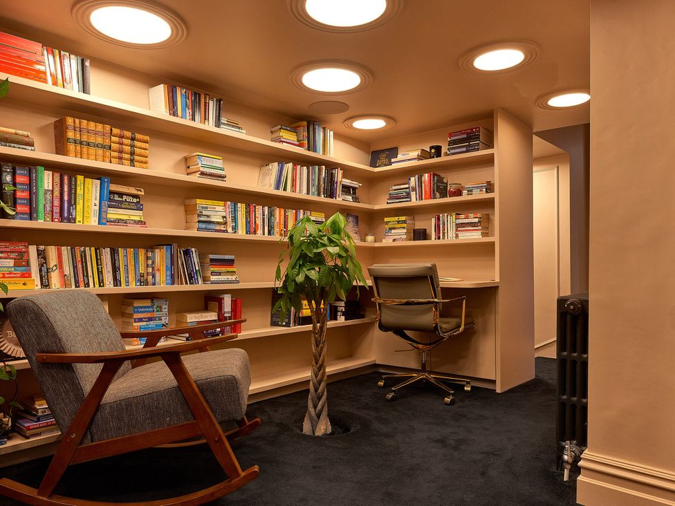 A study with bookshelves and a desk chair at Providence Cottage Trellech