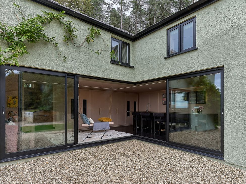An outdoor area with glass doors and gravel at Providence Cottage Trellech