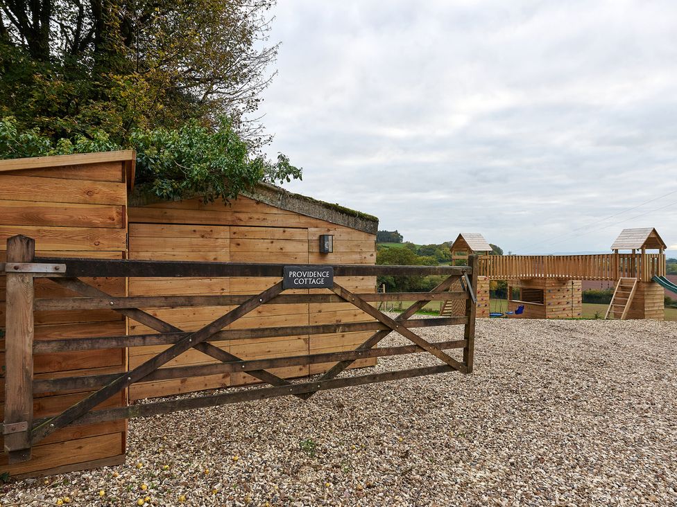 An outdoor area with a gate and play structure at Providence Cottage in Trellech