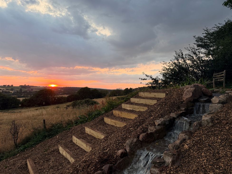 A sunset with stairs and a water feature at Providence Cottage Trellech