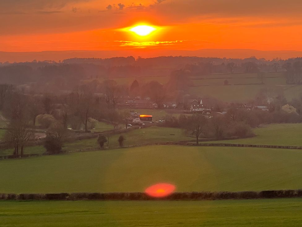 A sunset over fields and hills at Providence Cottage Trellech