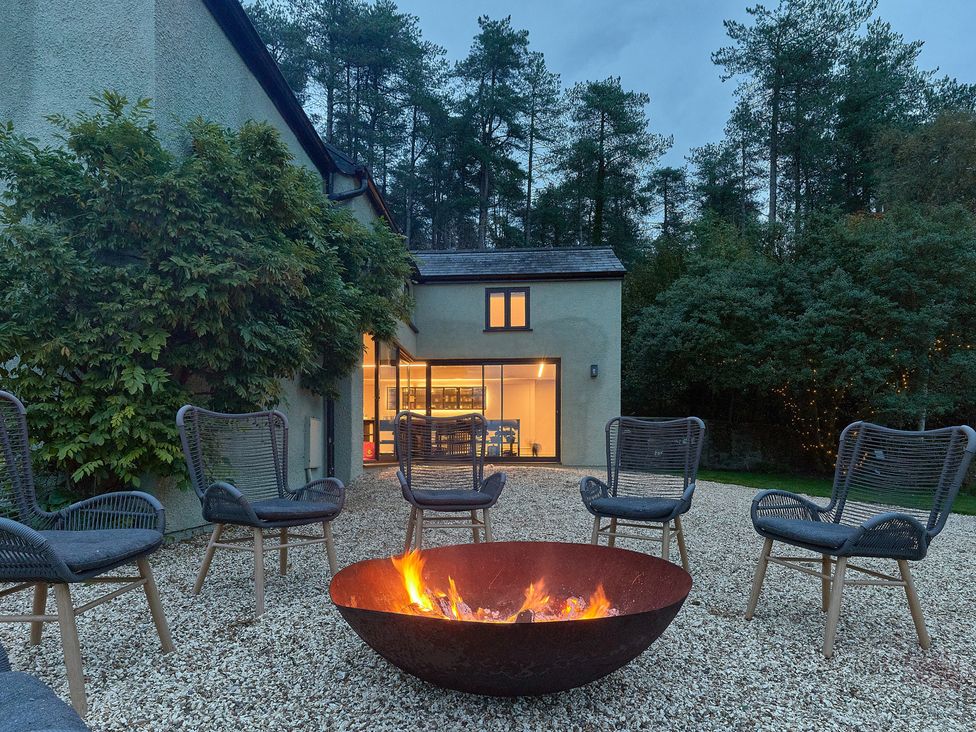 An outdoor area with a fire pit and chairs at Providence Cottage in Trellech