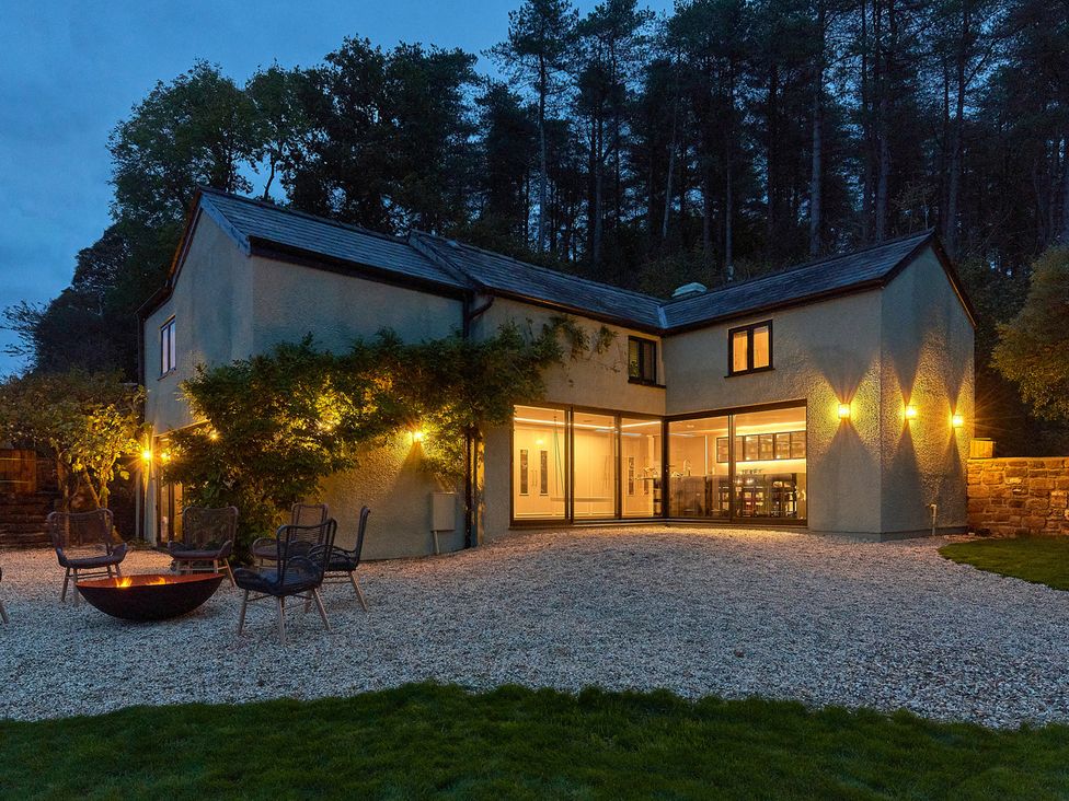 An exterior view of a house with outdoor seating and a fire pit at Providence Cottage Trellech