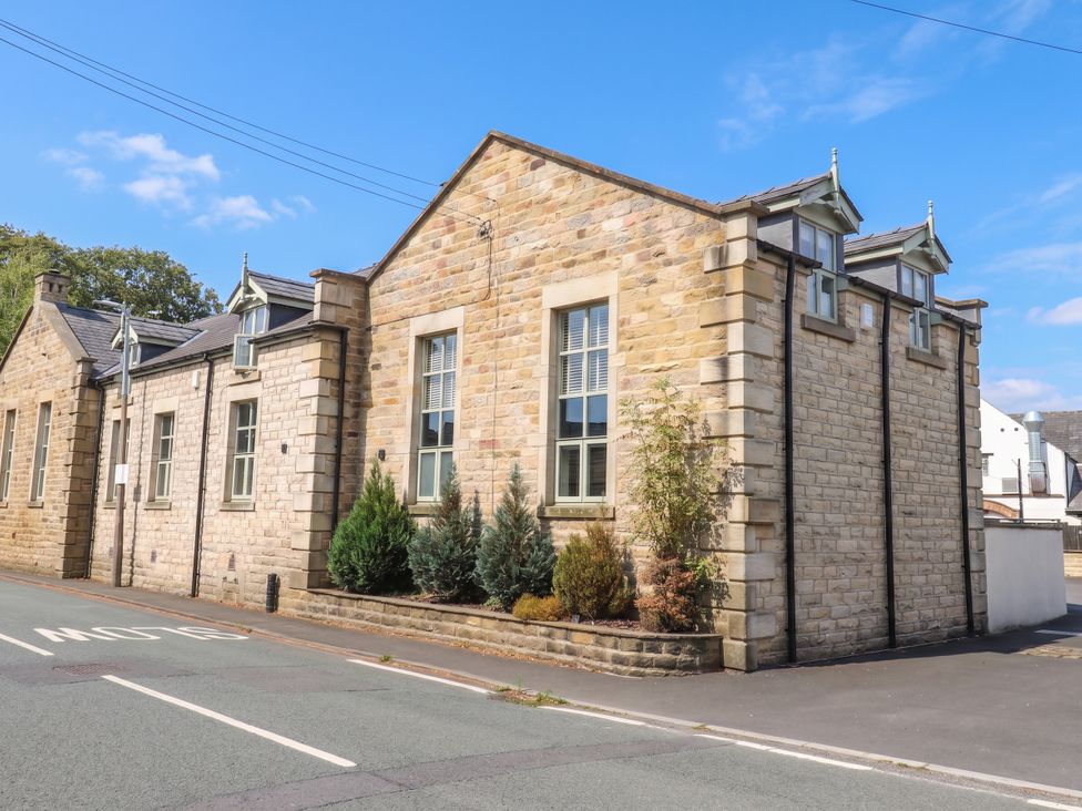 A stone building with windows and plants at 4 Church Hall Mews Garstang