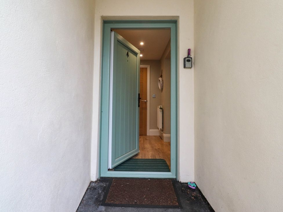 An entrance with a green door opening to a hallway at 4 Church Hall Mews Garstang