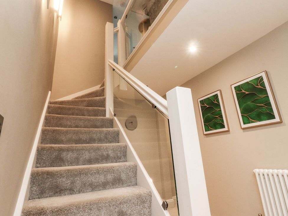 A staircase with carpeted steps and wall art at 4 Church Hall Mews Garstang