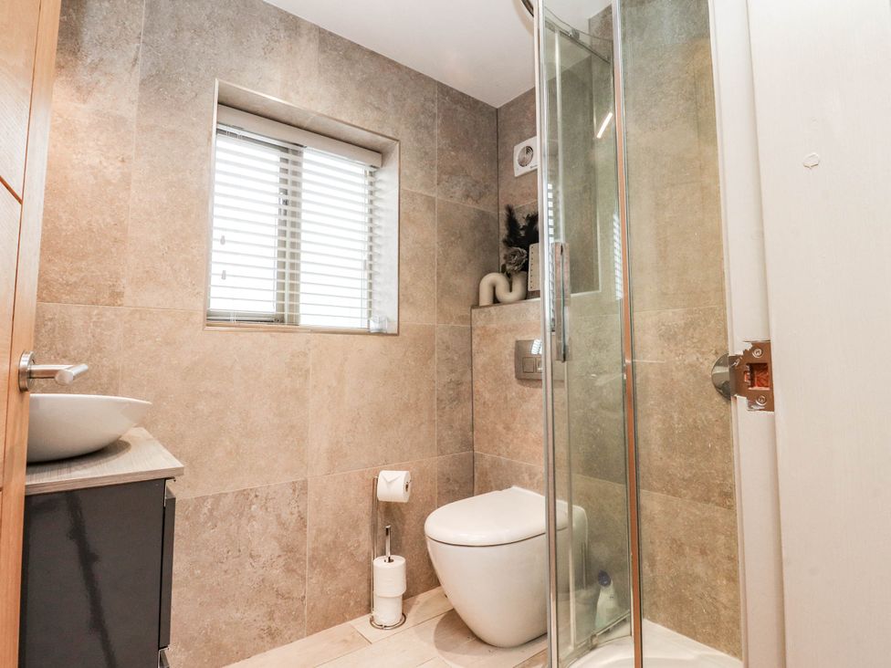 A bathroom with a shower, toilet, and sink at 4 Church Hall Mews Garstang