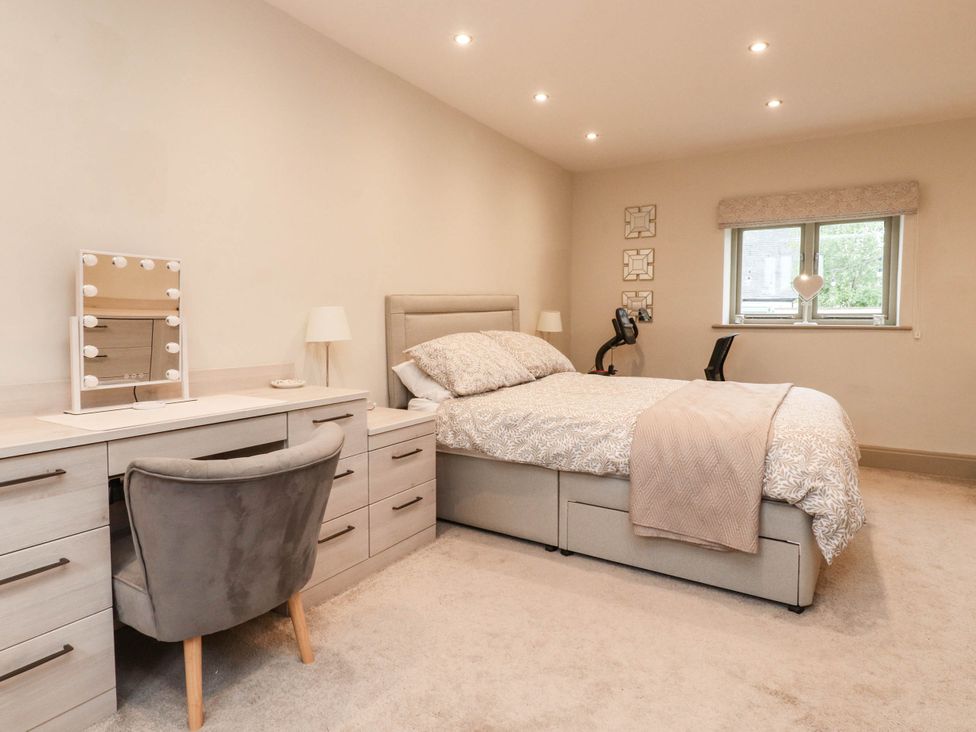 A bedroom with a bed, desk and mirror at 4 Church Hall Mews Garstang