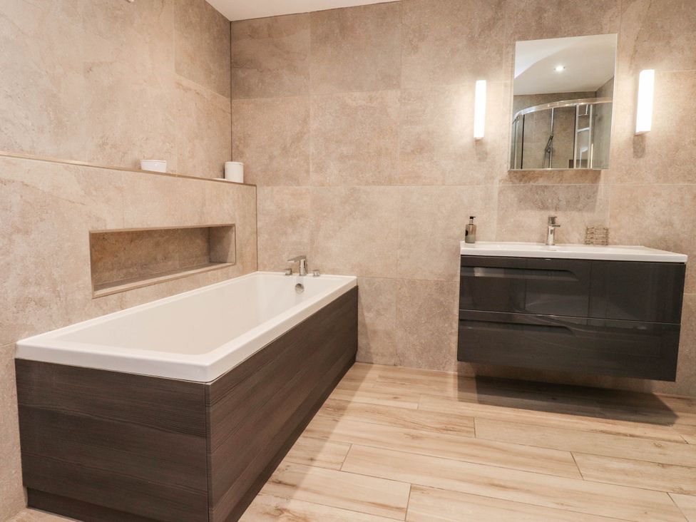 A bathroom with a bathtub and sink at 4 Church Hall Mews Garstang