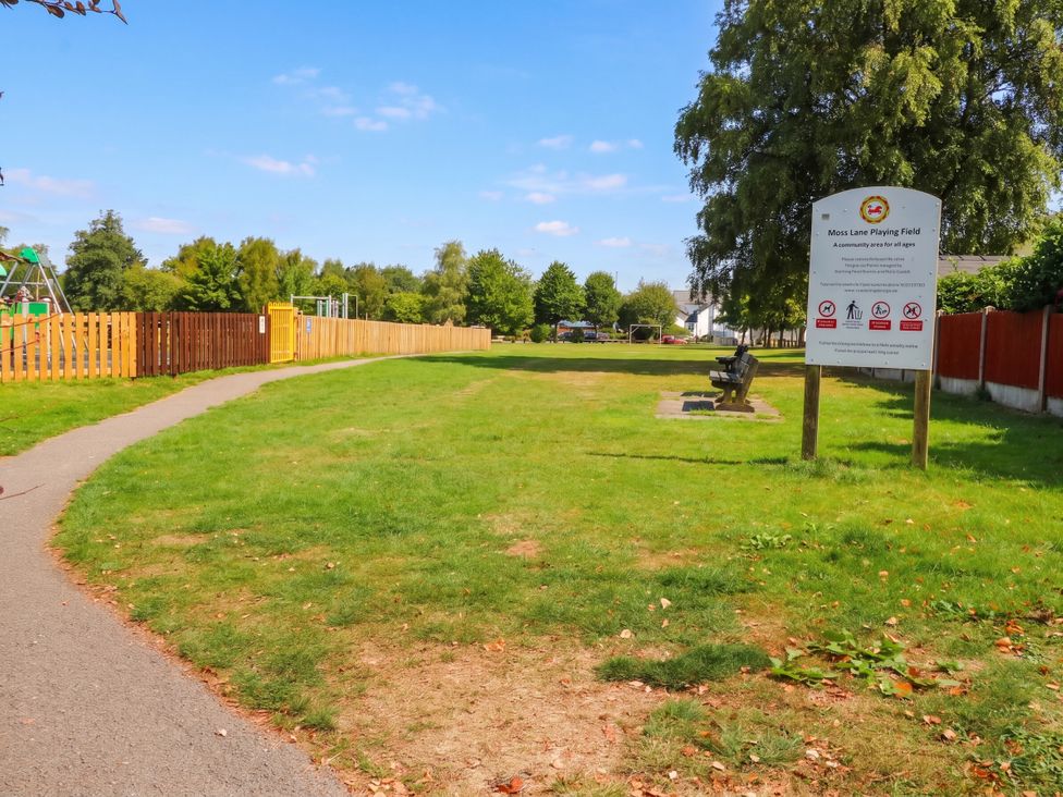 A park with a sign and playground equipment at Moxx Lane Playing Field in Garstang