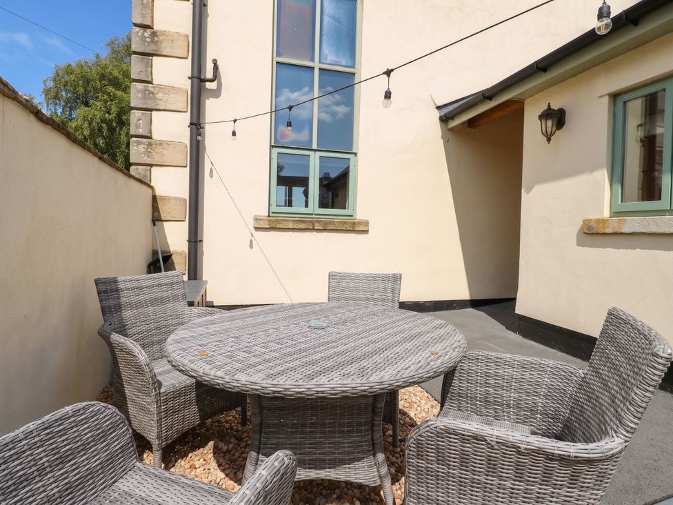 An outdoor seating area with a round table and chairs at 4 Church Hall Mews Garstang