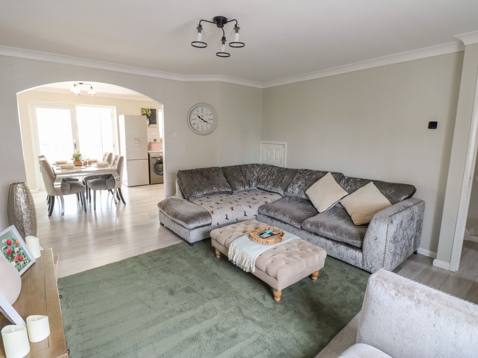 A living room with a sofa, coffee table and view of kitchen at 4 Murrayfields in Newcastle upon Tyne