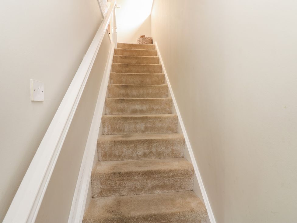 A staircase with carpet and a handrail at 4 Murrayfields in Newcastle upon Tyne