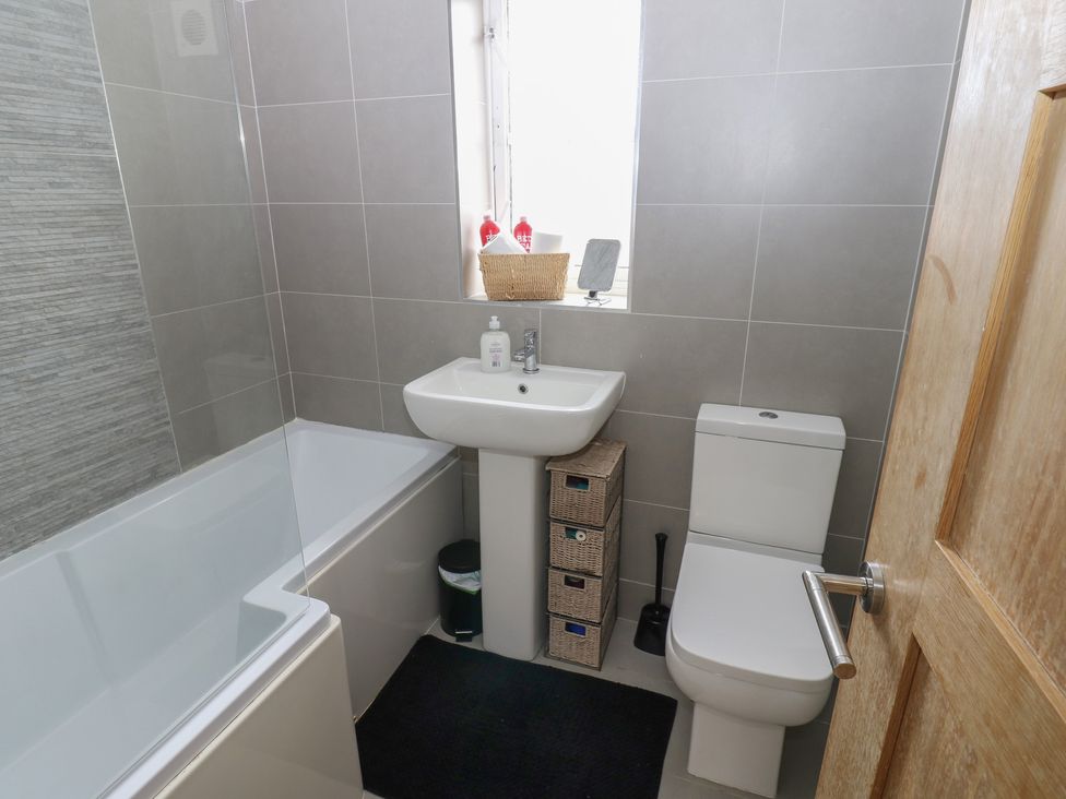 A bathroom with a bath tub, sink, and toilet at 4 Murrayfields in Newcastle upon Tyne
