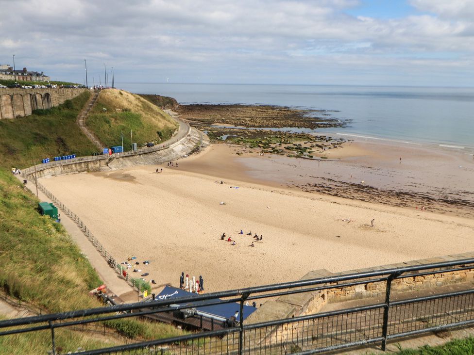 A beach with sand and water with people at 4 Murrayfields Newcastle upon Tyne