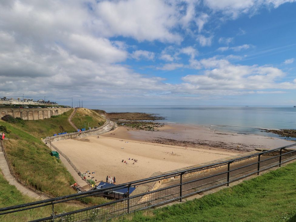 A beach with sand and water under a cloudy sky at 4 Murrayfields Newcastle upon Tyne