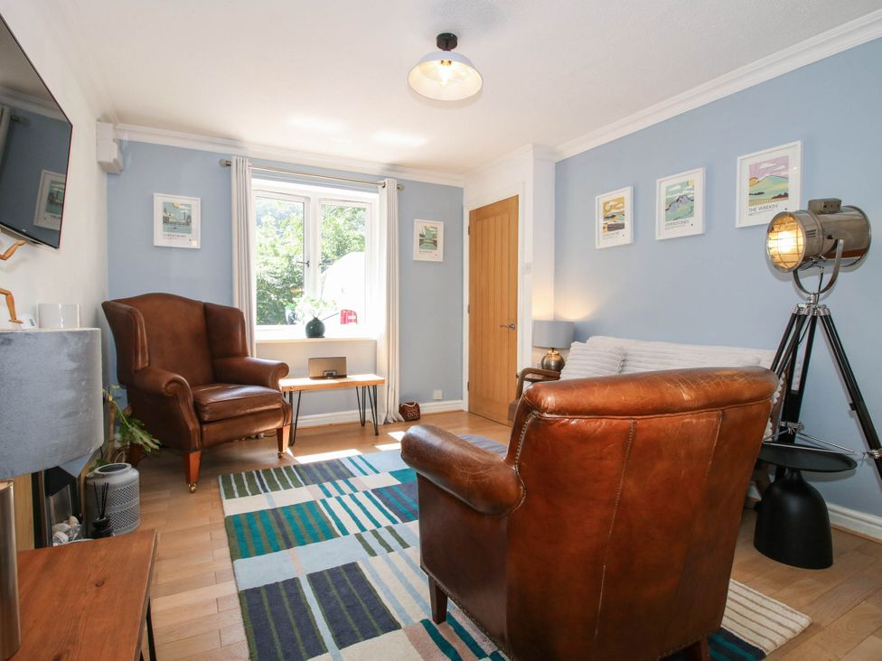 A living room with an armchair and a coffee table at Lilac Cottage in Ironbridge