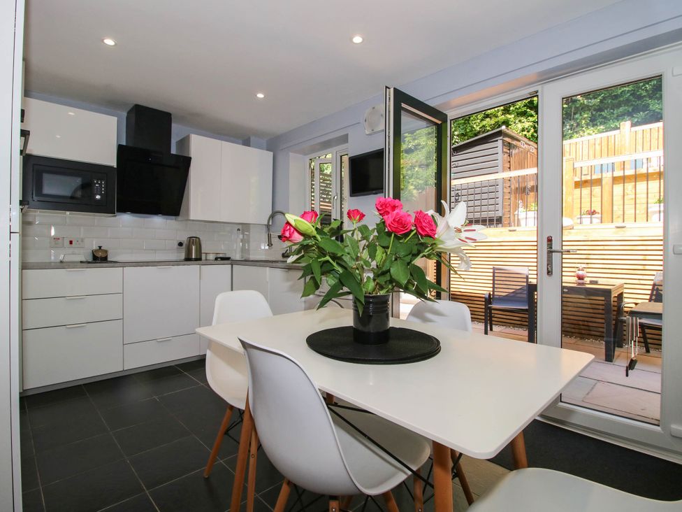 A kitchen with a table and chairs at Lilac Cottage in Ironbridge