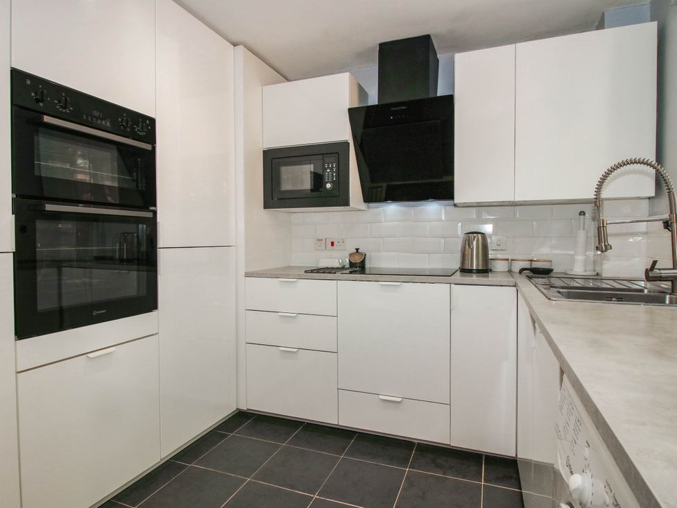 A kitchen with appliances and cabinets at Lilac Cottage in Ironbridge