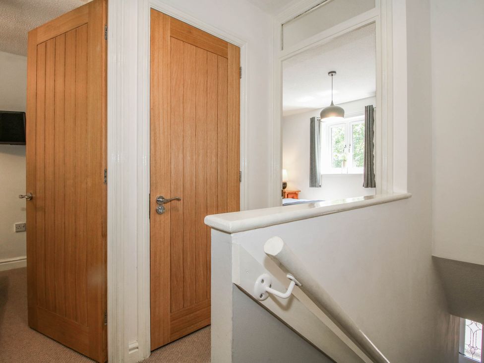 A hallway with doors and staircase at Lilac Cottage in Ironbridge