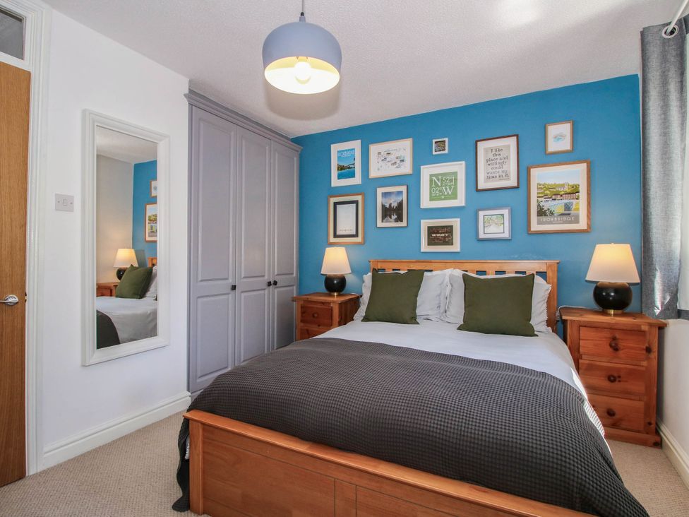 A bedroom with a bed and wall art at Lilac Cottage in Ironbridge