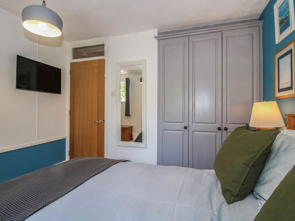 A bedroom with a bed and television at Lilac Cottage in Ironbridge